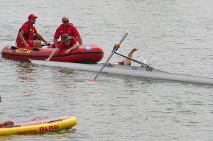 Die zu rettende Person im Rudereiner fällt ins Wasser, als das DLRG-Boot das Ruderboot berührt.