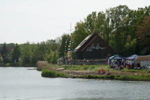 Blick auf das Bootshaus am Kanal mit bunten Flaggen