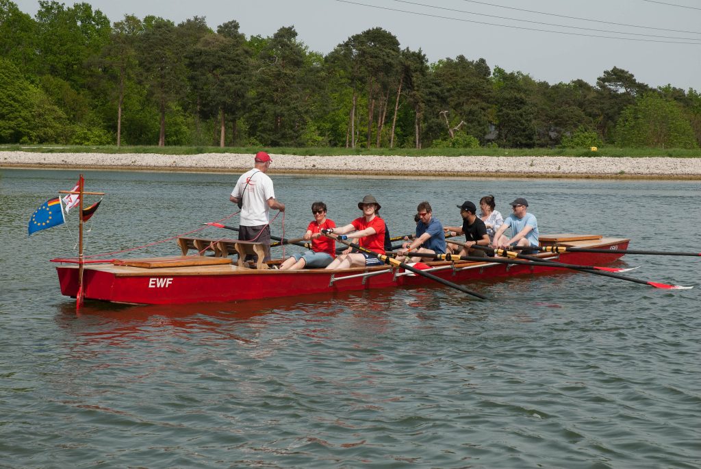 Eine Ruder-Barke mit acht Personen und einem Steuermann